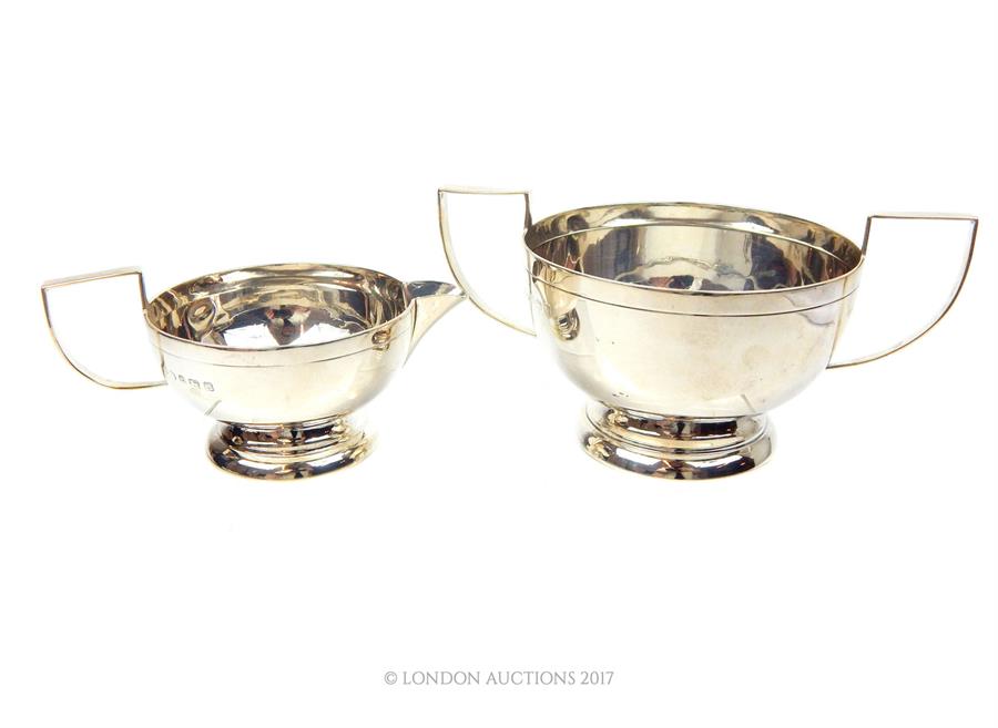 A matching sterling silver sugar bowl and milk jug