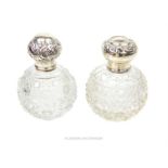 Two Edwardian cut glass perfume bottles with sterling silver lids and collars