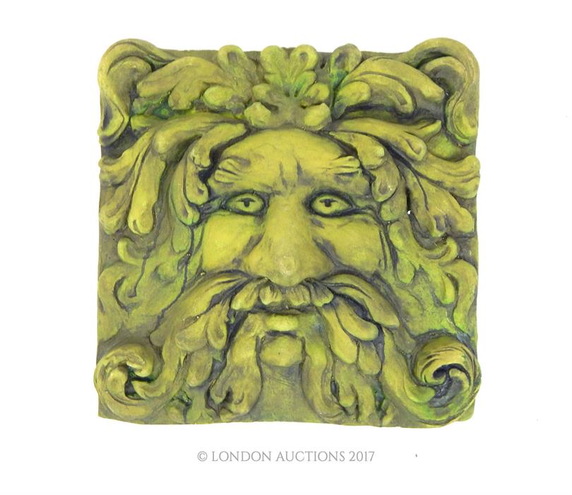 A green painted reconstituted stone plaque depicting the 'Green Man'