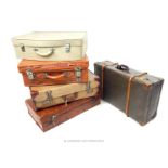 A collection of five vintage suitcases, including a tan leather suitcase
