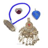 A Bedouin purple glass bead necklace with white metal pendent, a white metal headdress attachment