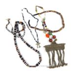 Four Bedouin coloured glass bead necklaces, including one with a large white metal pendant and