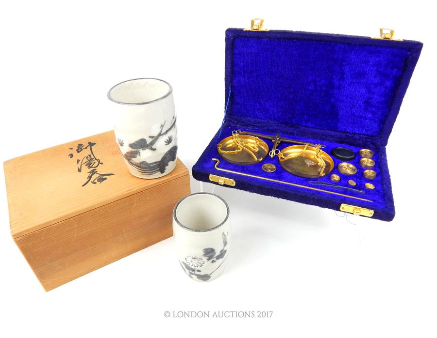 A boxed, set of brass scales and weights and two Japanese cups