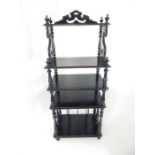 A late 19th century, ebonised pine etagere, with turned supports and periodical rack to its base;