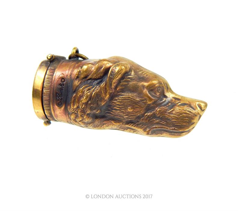 A brass vesta case in the form of a hound head; 7 cm long.