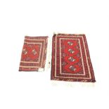 A pair of Bokhara prayer rugs, with four elephant foot motifs on a red field