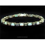 A silver CZ and opal style line bracelet; stamped 925.