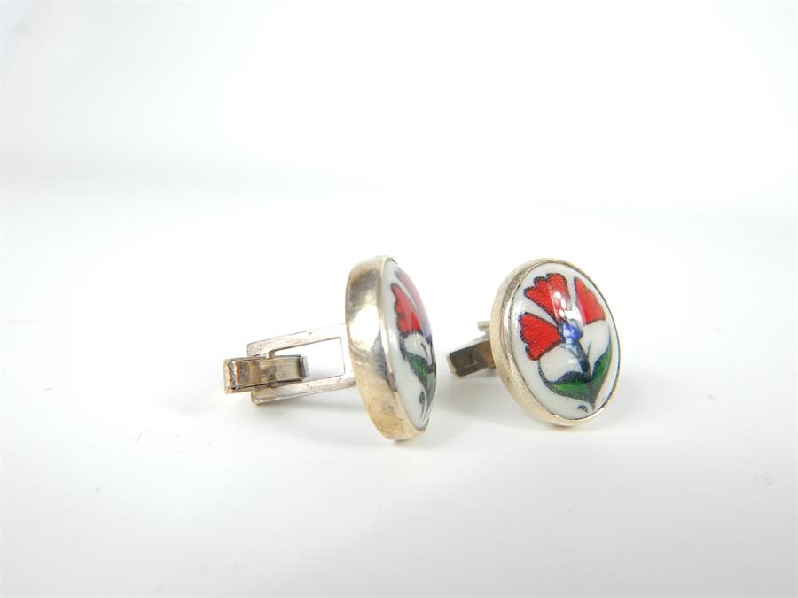 A pair of sterling silver and hand-painted, ceramic, oval, plaque cuff-links