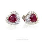A pair of heart shaped ruby and diamond earrings; stamped "750".