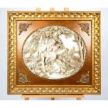 An oval decorative plaque depicting young lovers in relief, in a gilt frame