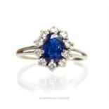A sapphire and diamond cluster ring (chip to sapphire) with white metal band; ring size "T".