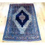 A Shiraz rug, having a central medallion on a midnight blue field with spandrels