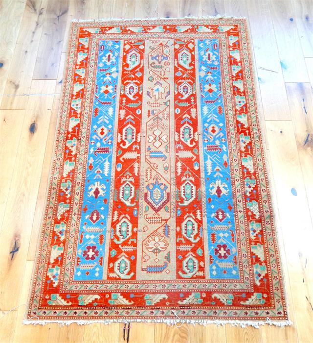 A Persian Kazak rug, with five bands of ivory, blue and red