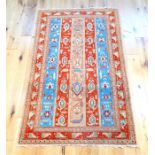 A Persian Kazak rug, with five bands of ivory, blue and red