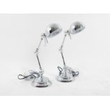 A pair of chromed articulated desk lamps