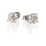 A pair of diamond stud earrings in white gold, stamped "14k".