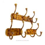 Three contemporary gilt metal wall mounted coat hooks