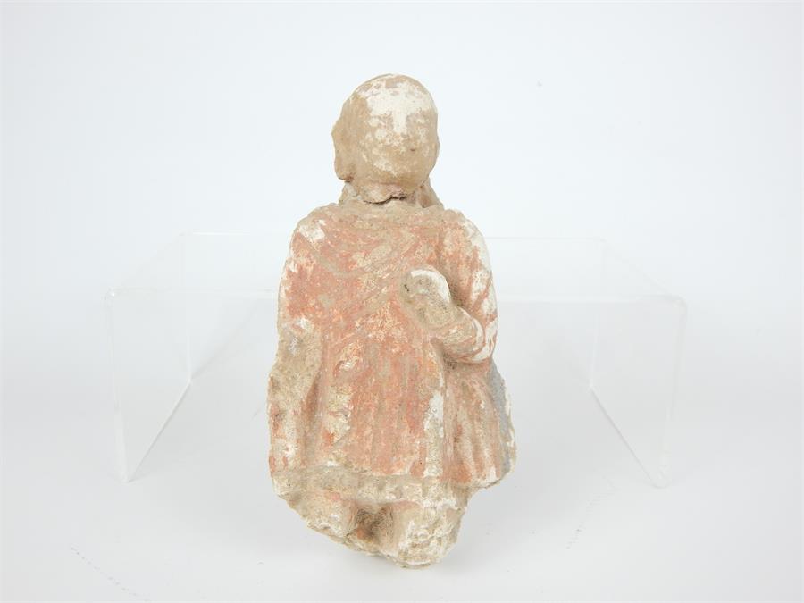 A carved sandstone image of Buddha with residue of red paint, either Chinese or Gandharan,