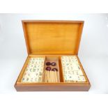 A Chinese Mahjong set made of bamboo and animal bone, in a well-patinated wooden Box (28.7cm wide).