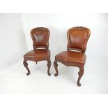 A pair Victorian walnut framed dining chairs with reverse scroll front legs and leather