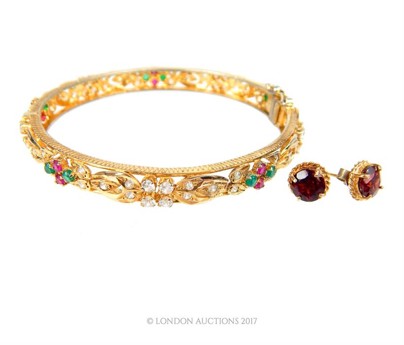 A pair of 9 ct yellow gold, garnet, stud earrings with a gem-set, yellow-metal bangle