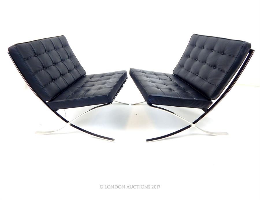 A pair of Barcelona style chairs, with buttoned black leather cushions