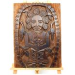 A large wooden, highly decorative and deeply- carved tribal/ ethnic panel