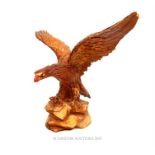 A resin figure of a majestic eagle, standing on a rocky outcrop with wings aloft