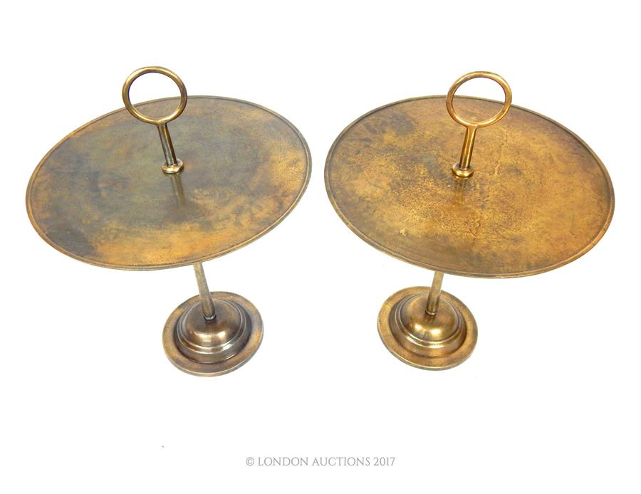 A pair of bronze circular occasional tables with hoop handles, raised on a circular step down base
