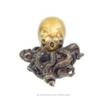 A contemporary bronze sculpture of an octopus, designed to sit on a shelf or ledge