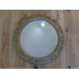 An antique, heavy, gilded and cast iron circular wall mirror