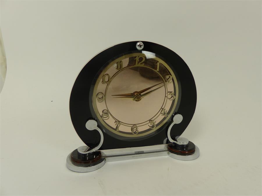 An Art Deco clock,having a circular peach mirror dial