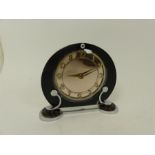 An Art Deco clock,having a circular peach mirror dial