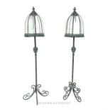 A pair of distressed metal storm lanterns on stands