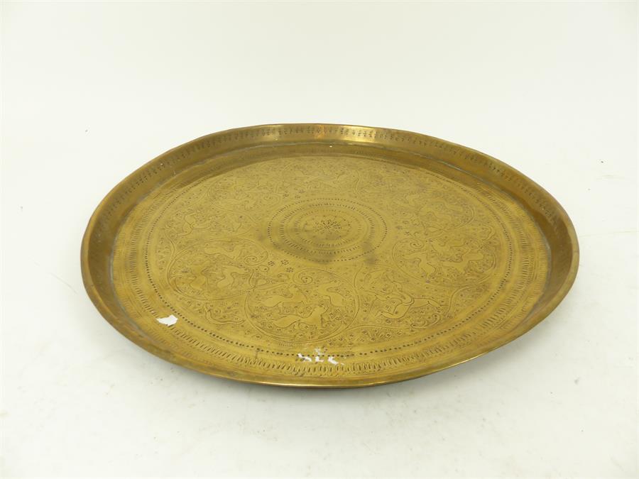 A circular brass tray with engraved detail