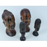 Four tribal style carved wood busts; largest 20cm high.