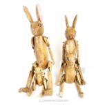 A set of four graduated, articulated, painted and distressed models of rabbits