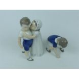 A Danish B & G figural group of a girl trying to kiss a boy (18cm high) together with a smaller