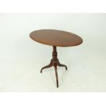 A mahogany oval tilt-top table.