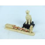 A Chinese carved ivory figure of a dog, with an Inuit carving