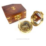 A reproduction, military, polished brass compass in fitted wooden and brass box