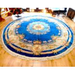 A large circular Chinese rug, having a floral medallion on a royal blue field