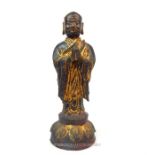 A bronze Tibetan standing Buddha, with areas of original colour decoration; 28cm high.