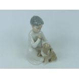 A Lladro porcelain figurine of a boy with a puppy; 19.5cm high.