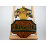 A reproduction painted wooden coat rack in the form of a greengrocer's sign