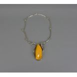 A silver colour necklace with amber pendant