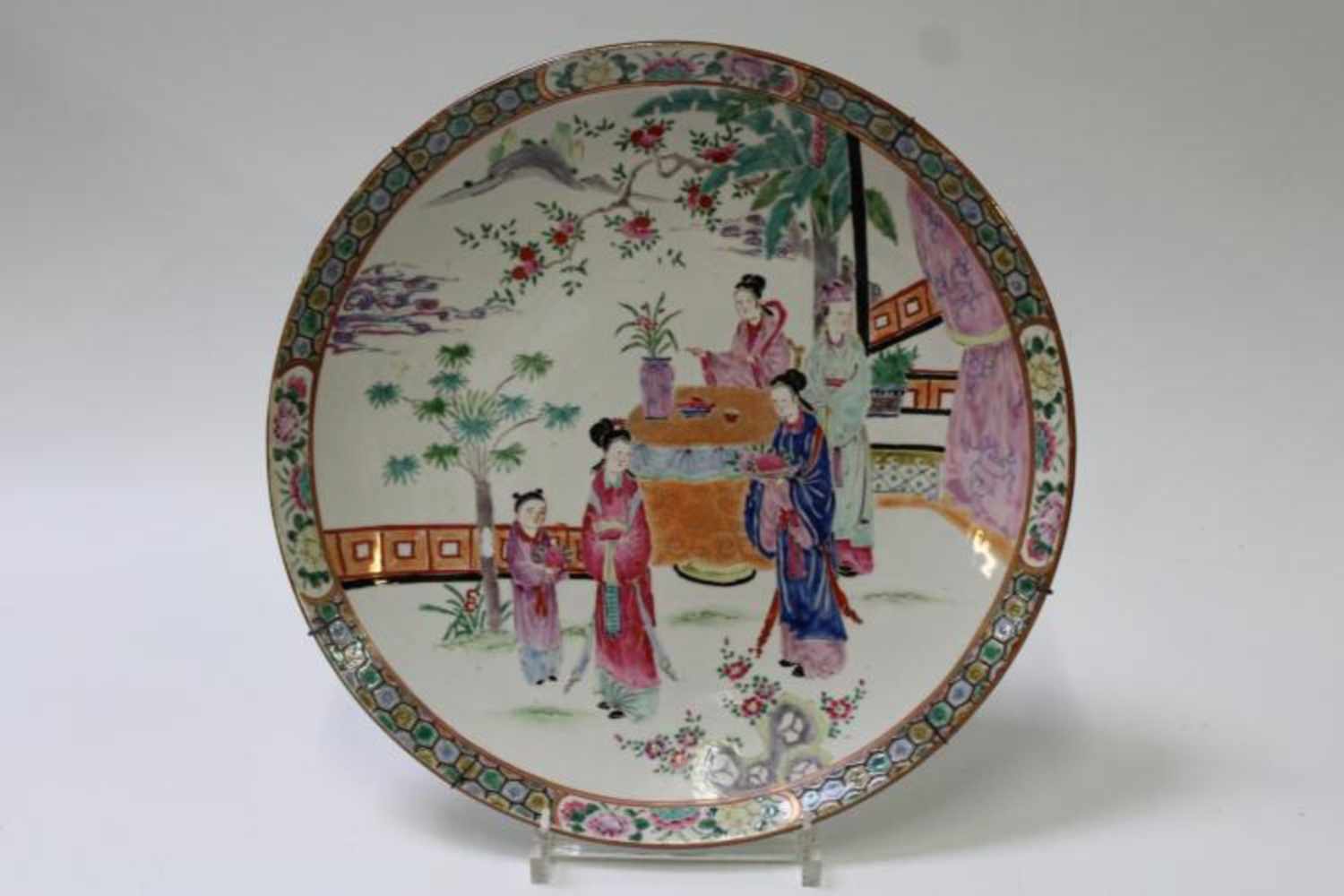 Polychrome schotel met decor van vele personages, diam. 45 cm.