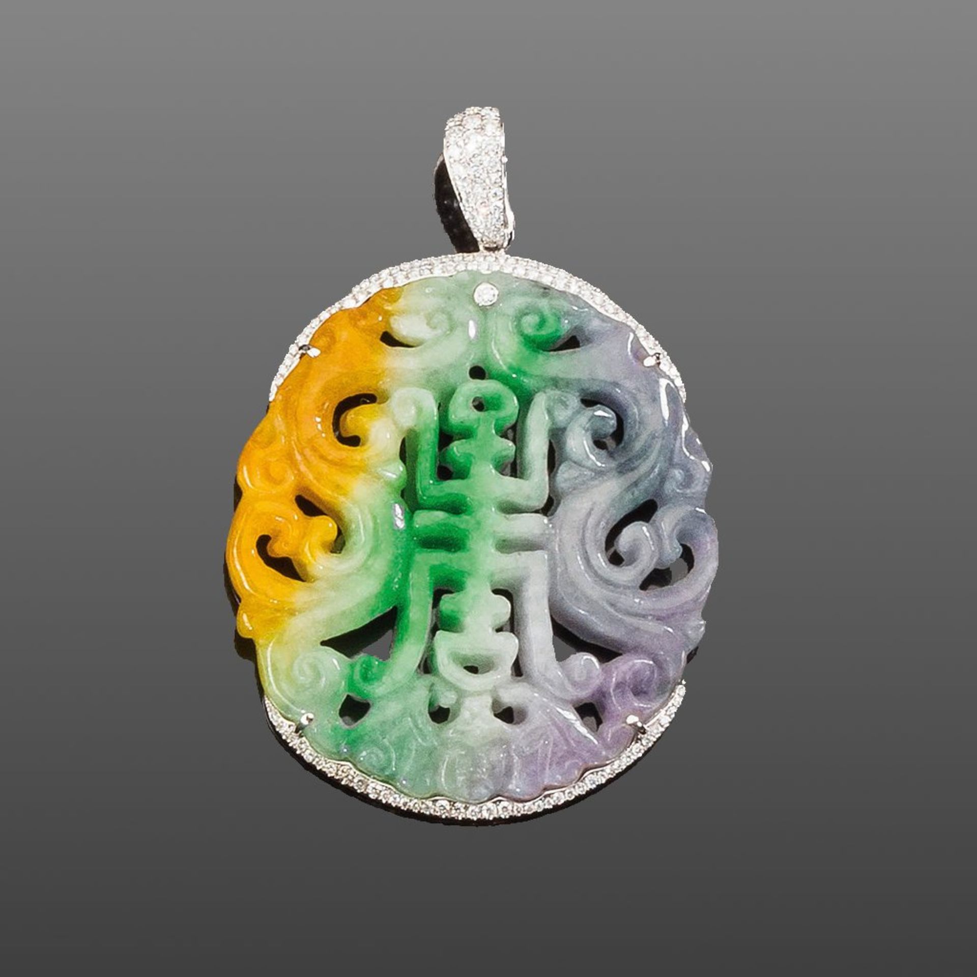 Großer Jadeanhänger. Mehrfarbige Jade, ornamental geschnitten mit glückhaftem Zeichen. Brillanten