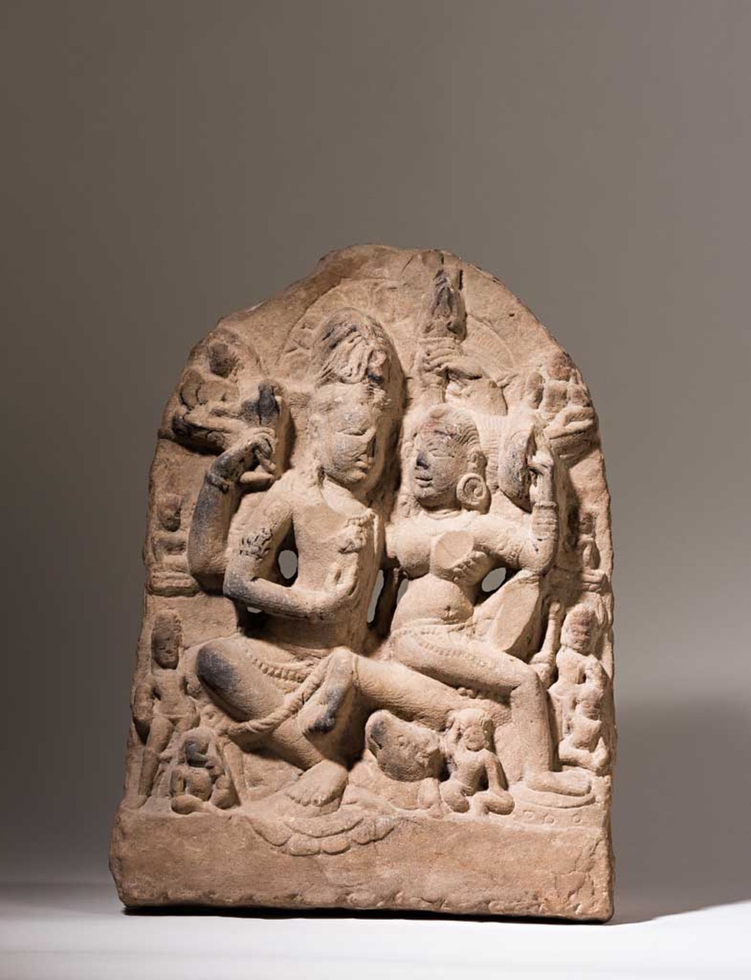 Umamahesvara-Reliefstele. Das göttliche Paar Shiva und Parvati in Umarmung, von zahlreichen