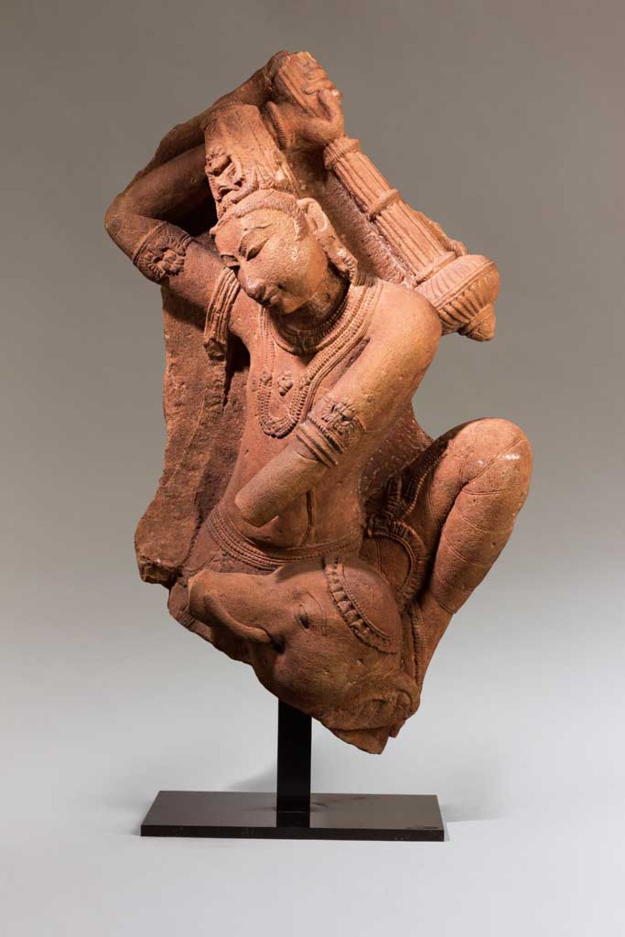 Shiva oder Vishnu. Fragment einer großen Skulptur. In der erhobenen Rechten den Streitkolben